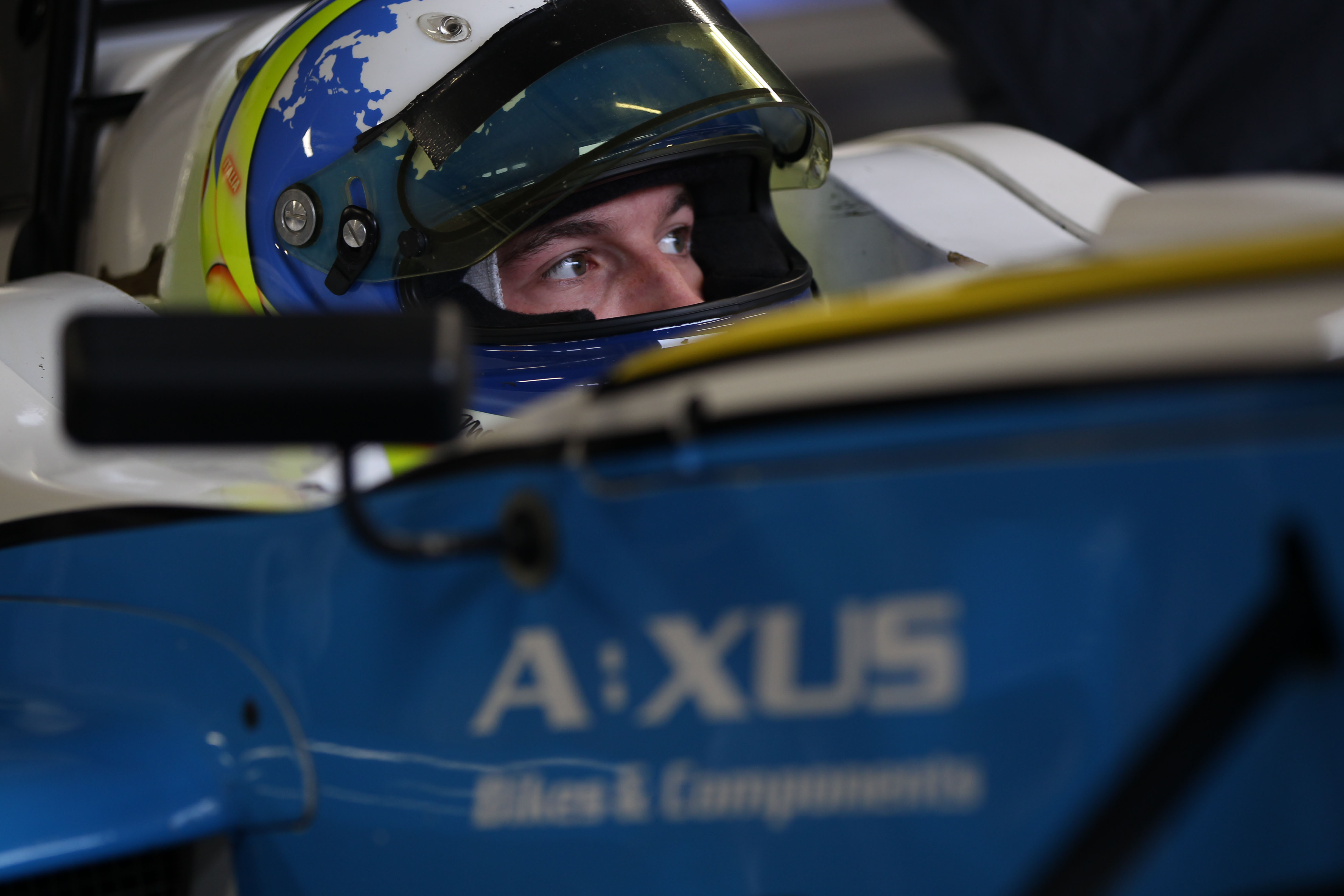 Matteo Ferrer sits in his car with his helmet on at Brands Hatch in the 2013 Formula 4 Winter Championship